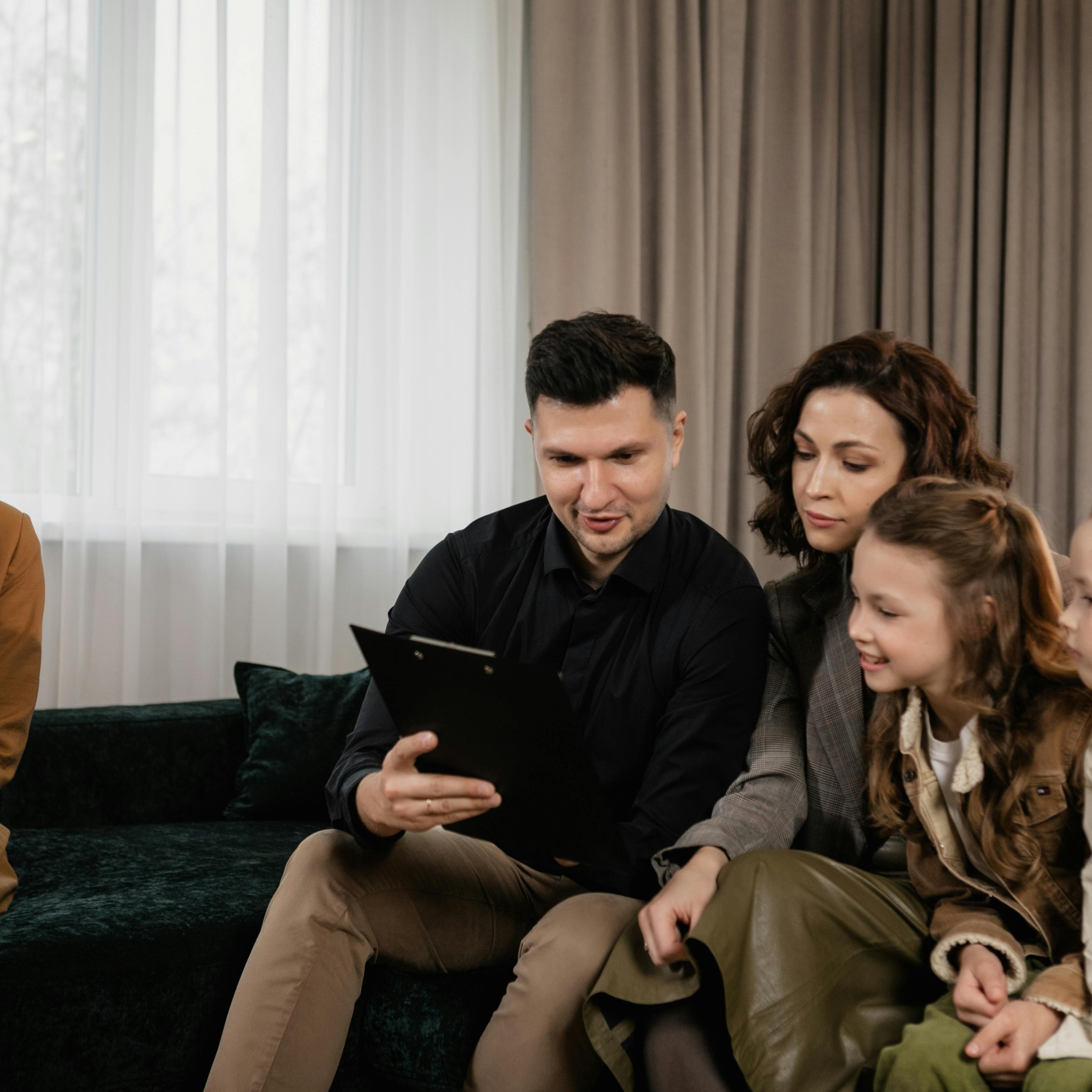Senior financial advisor reviewing a planning binder with a client family