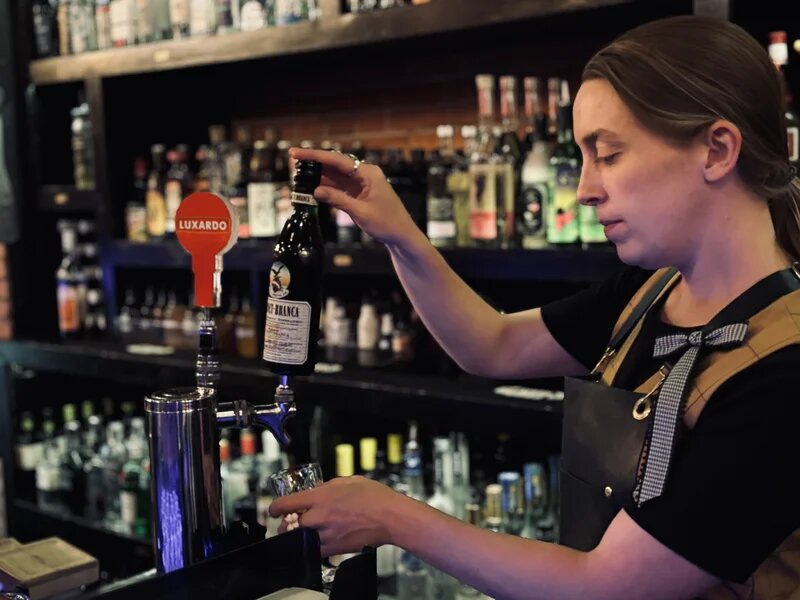 Bartender selecting spirits from our mezcal collection