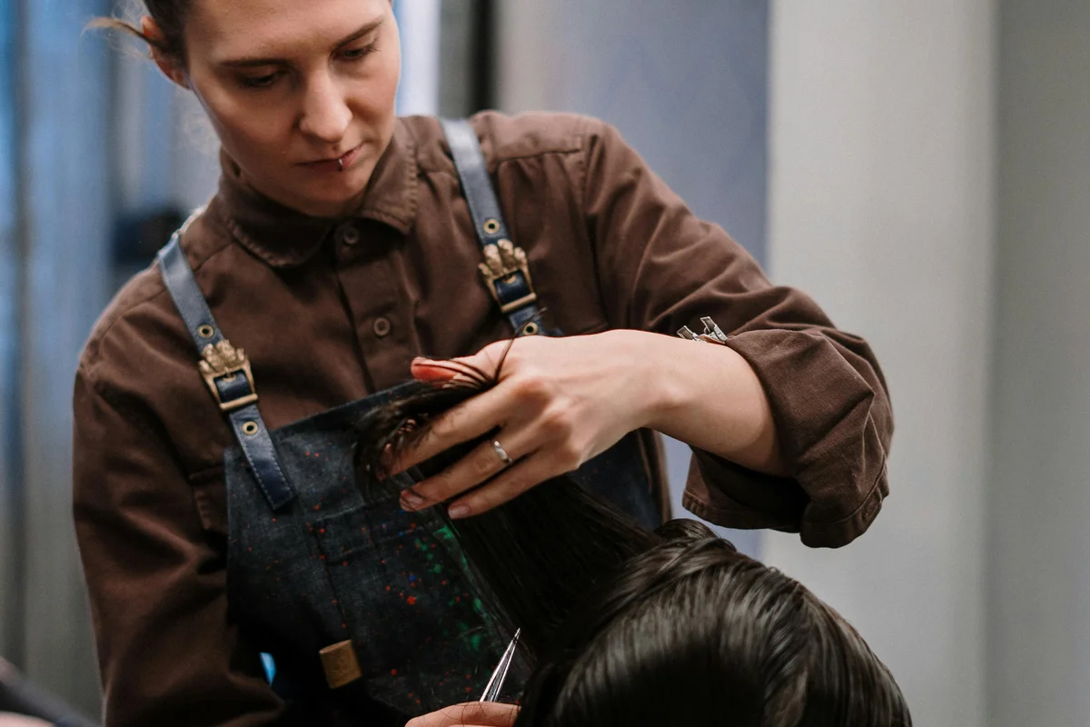Maya Chen, lead stylist and founder of Bloom Hair Studio, working with a client
