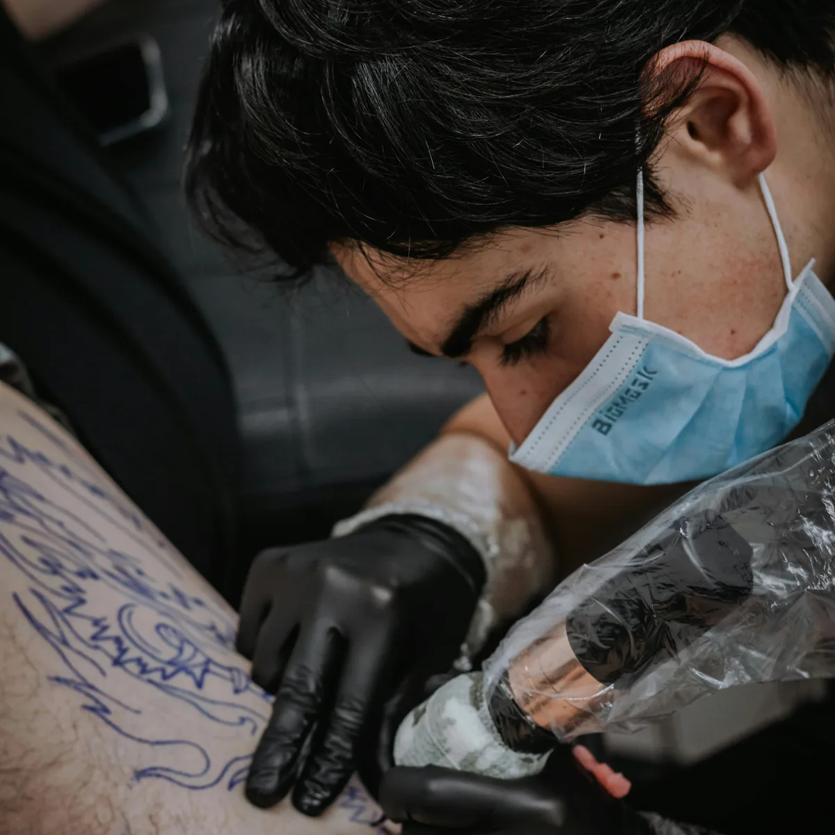 Cover-up tattoo in progress transforming a dated piece into bold blackwork