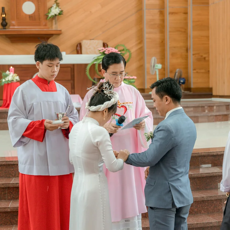Three-tiered wedding cake adorned with cascading fresh flowers and ribbon